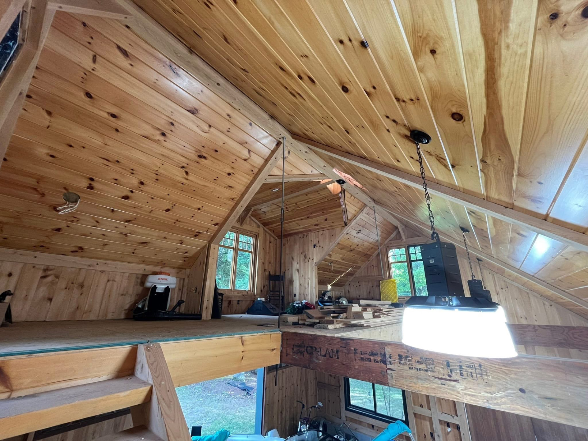 Finished pine loft interior with clear-sealed board ceilings and exposed beams