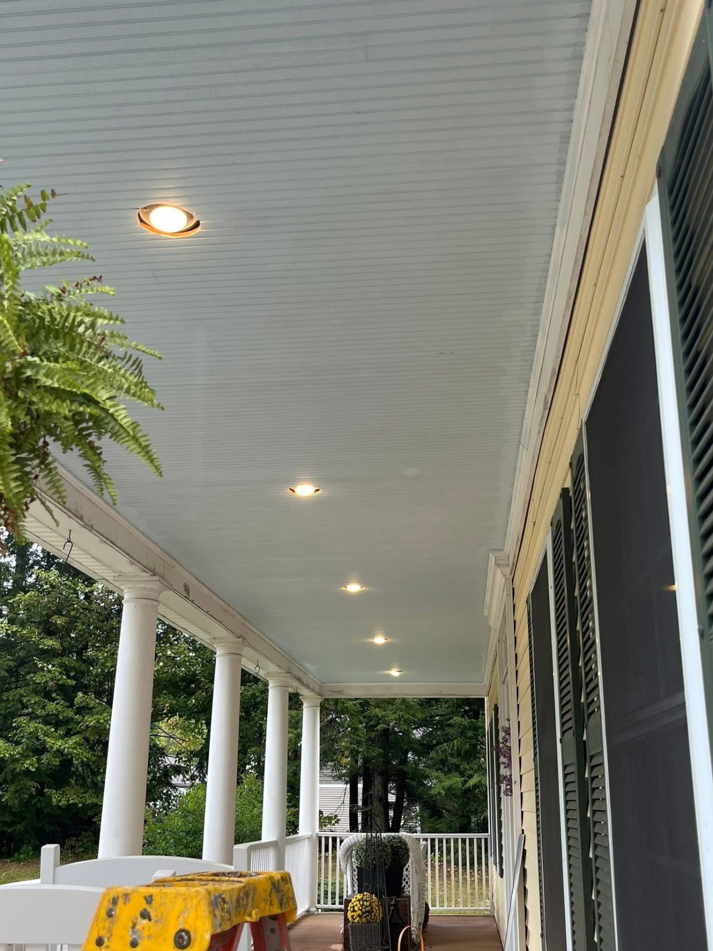 Same porch after painting with a bright white beadboard ceiling and clean recessed lighting