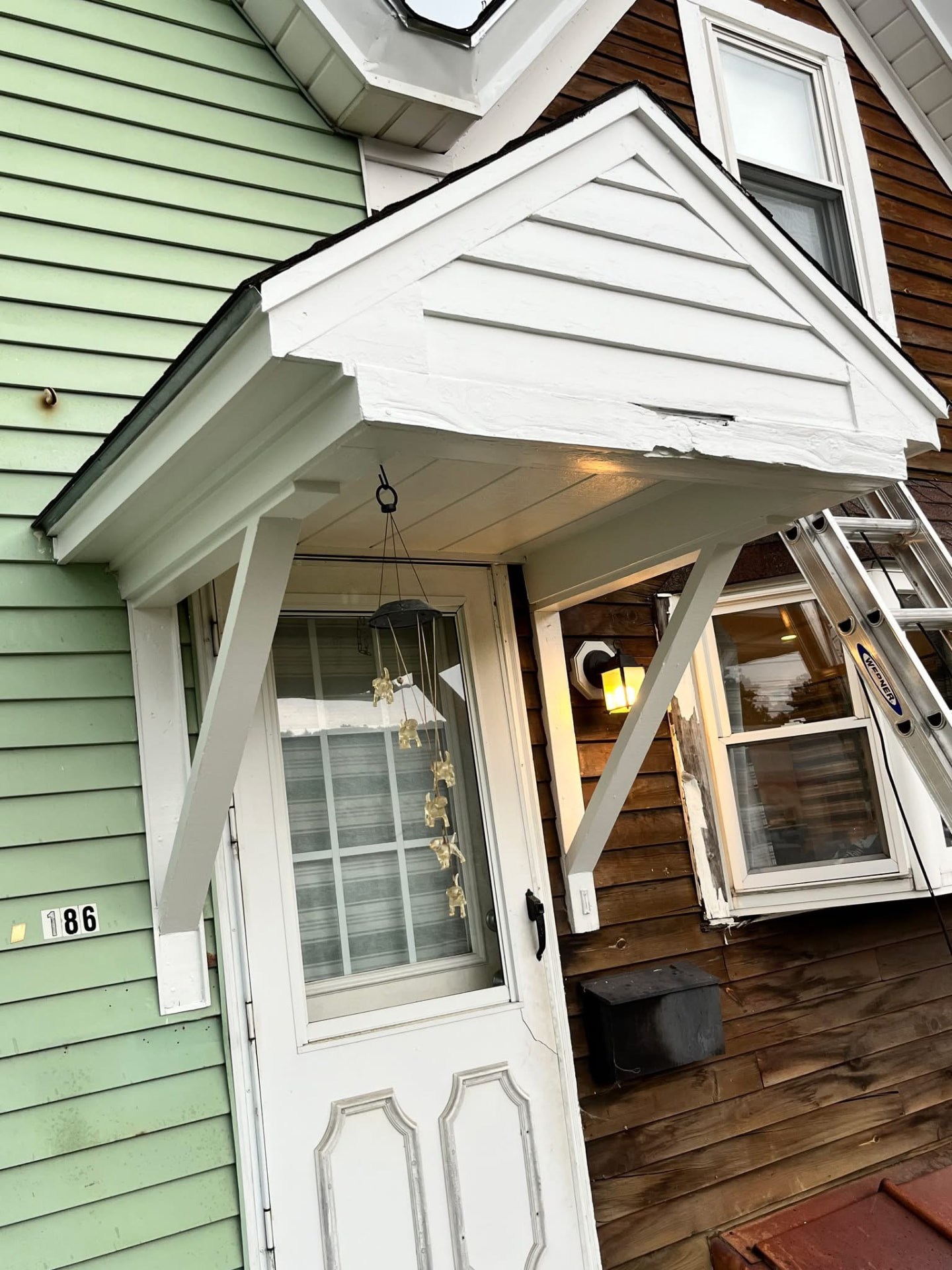 Same entry portico after scraping, priming, and repainting with a smooth crisp white finish